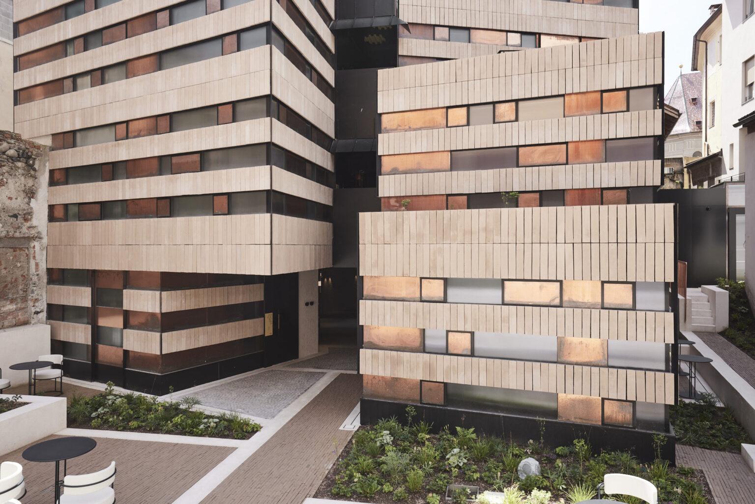 Das 4 Sterne Boutique Hotel Badhaus im Zentrum von Brixen in Südtirol mit seiner aussergewöhnlichen Fassade und modernen Architektur von Innenhof aus betrachtet.