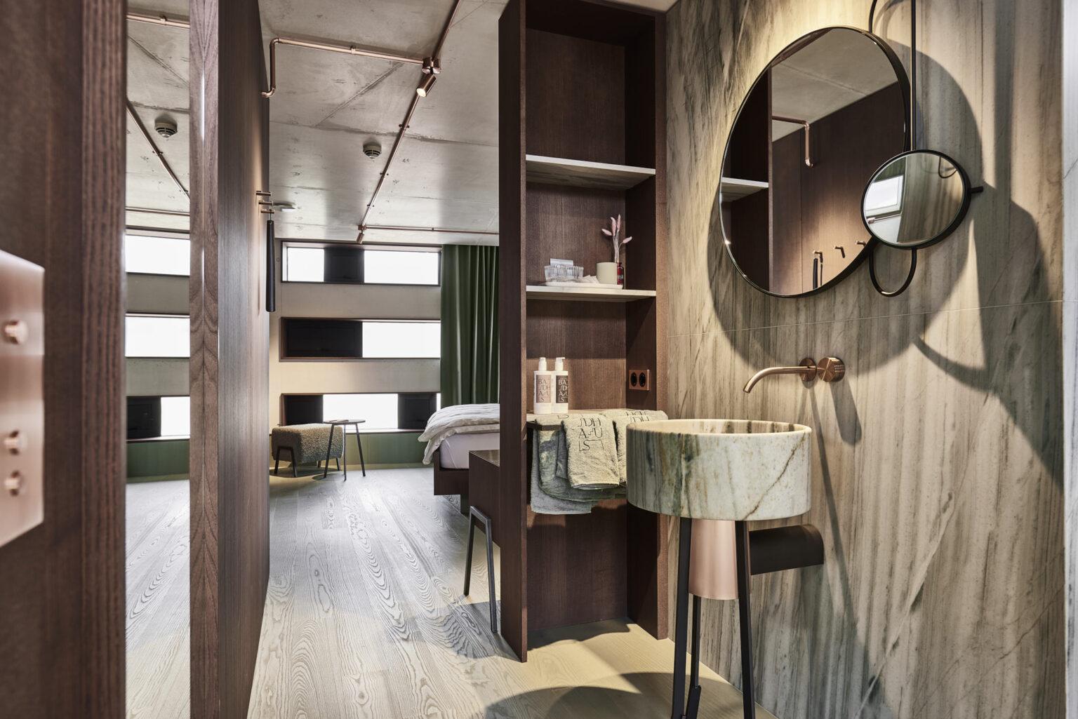 Helles Turmzimmer im Boutique Hotel Badhaus mit italienischen Leinen und Holzboden, Blick auf den Sanitärbereich.