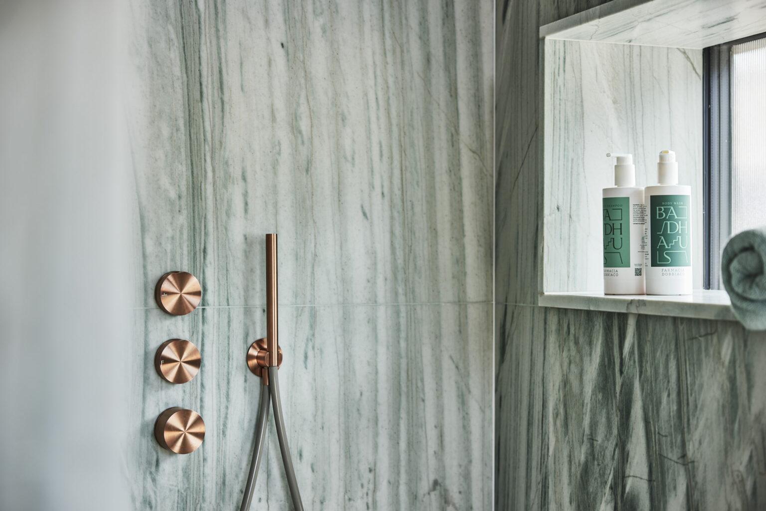 Helles Turmzimmer im Boutique Hotel Badhaus mit italienischen Leinen und Holzboden, Blick auf die Dusche.