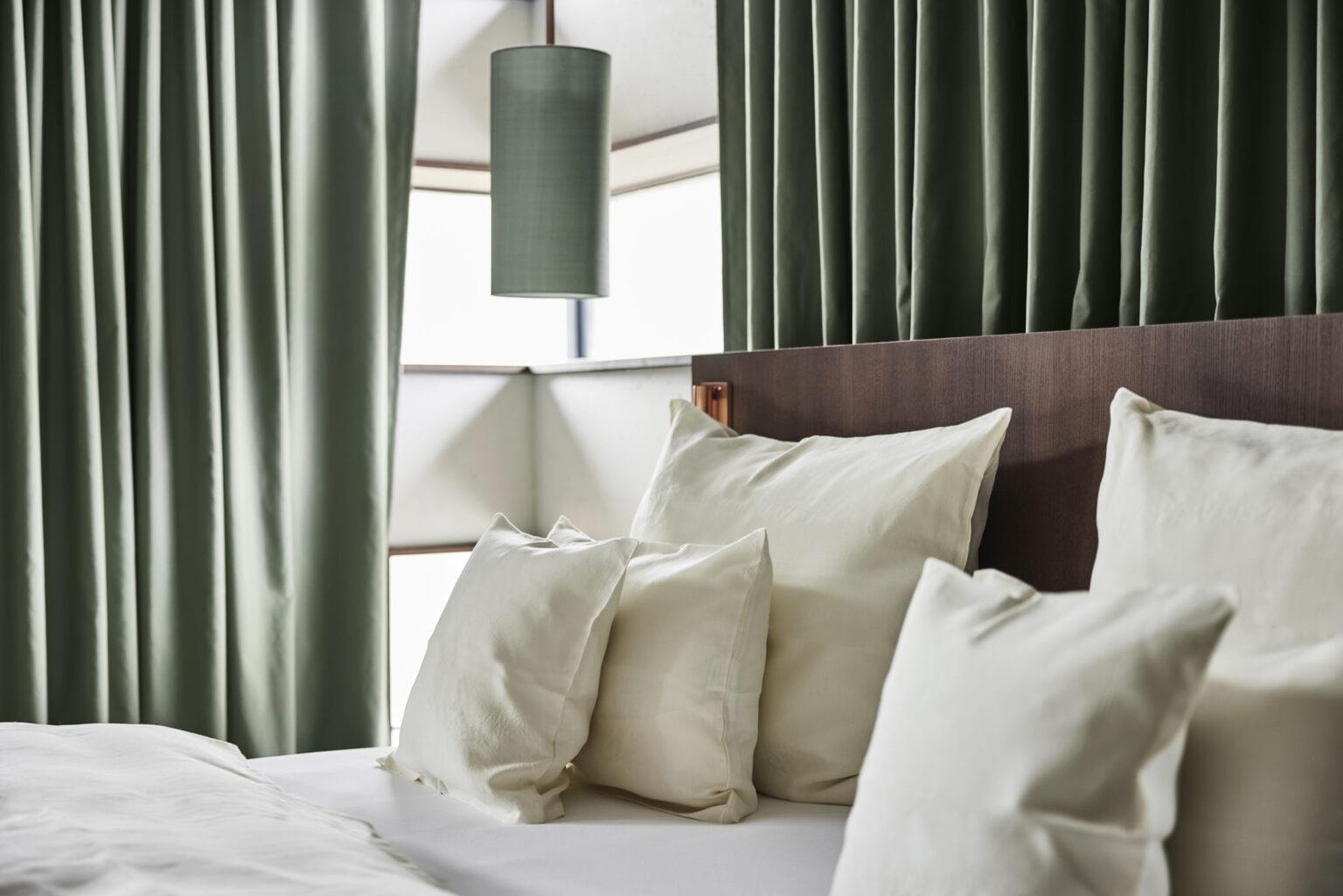 Helles Turmzimmer im Boutique Hotel Badhaus mit italienischen Leinen und Holzboden, Pölster und Bett