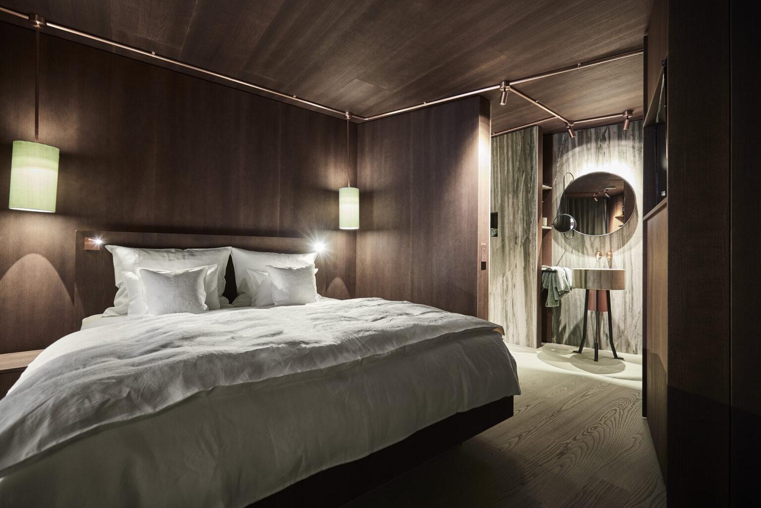 Parterre-Zimmer im Boutique Hotel Badhaus mit italienischem Leinen, Holzboden, Zugang zur Terrasse und Blick in den Sanitärbereich